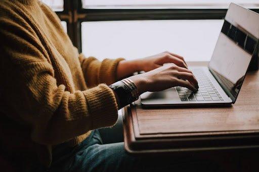 A person engaged in typing on a laptop, symbolizing innovation in utilities through effective knowledge management.